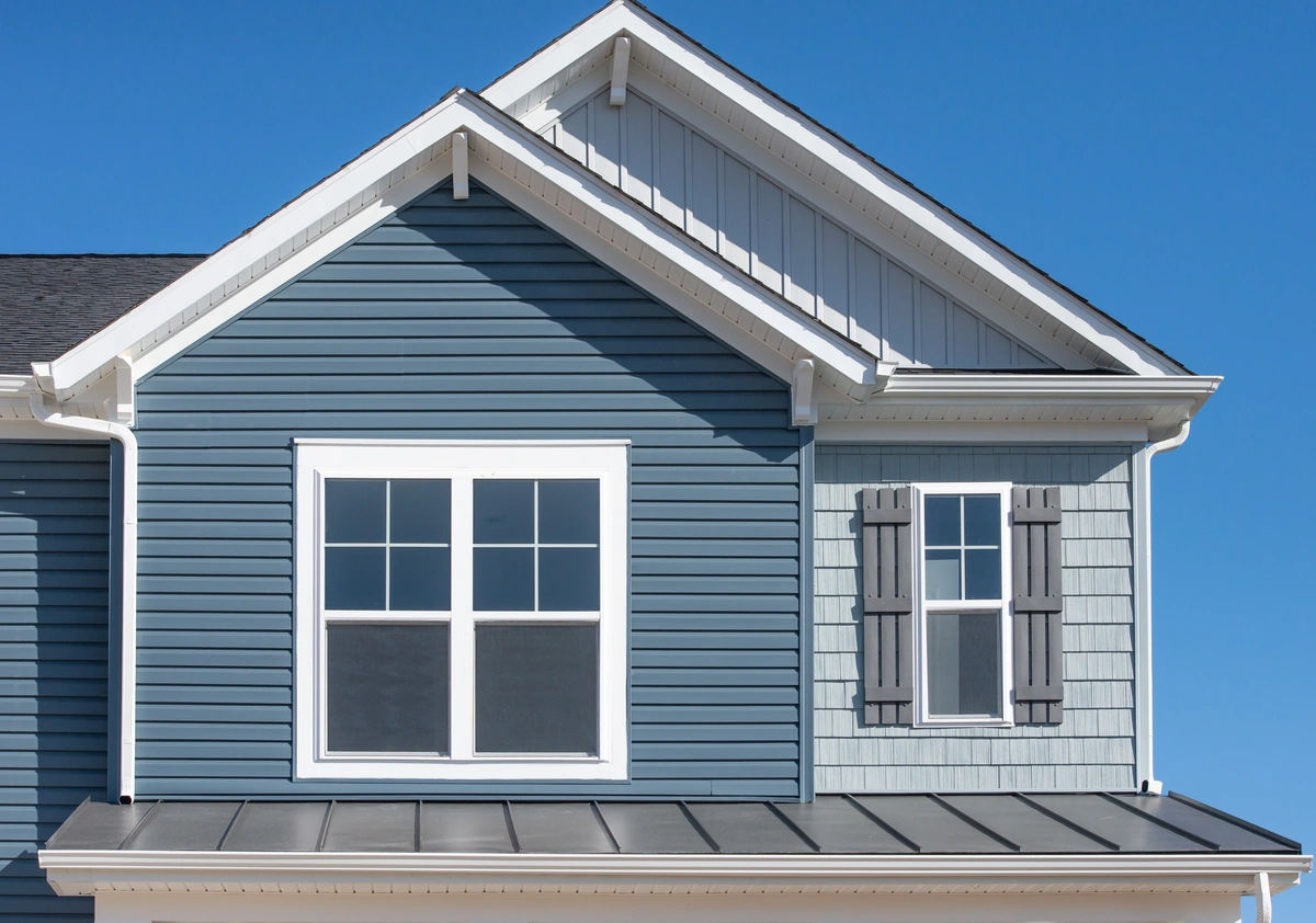 blue vinyl siding on gable roof home- How much does siding replacement cost